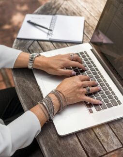 Photo by LinkedIn Sales Solutions person typing on MacBook Pro on brown wooden table during daytime photo